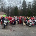 Photo souvenir des motards, bénévoles, familles d'accueil, maîtres-chiens guides et salariés présents